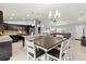 Open-concept kitchen features dark wood cabinetry, granite countertops, and a dining table with seating at 5954 Gottfried Ln, North Port, FL 34291