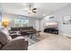 Living room with vaulted ceiling, ceiling fan, large sectional and adjacent to the kitchen at 5954 Gottfried Ln, North Port, FL 34291