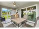 Cozy screened patio with comfortable seating, a ceiling fan, and sliding glass doors leading to the home's interior at 5954 Gottfried Ln, North Port, FL 34291