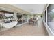 Large tiled screened porch with ceiling fans, patio furniture, and backyard views at 612 Bayshore Rd, Nokomis, FL 34275