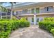 Exterior view of a condo building entrance with lush landscaping, stairs, and well-maintained walkways at 614 Guild Dr # 10, Venice, FL 34285