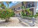 Building exterior showcasing black railings, palm trees, and decorative rock landscaping at 614 Guild Dr # 10, Venice, FL 34285