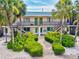 Two-story building with tropical landscaping, stairs, and walkway to the entrance at 614 Guild Dr # 10, Venice, FL 34285