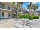Exterior of building, featuring tropical landscaping and a stone table and bench at 614 Guild Dr # 10, Venice, FL 34285