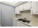 The kitchen features a double basin sink, sleek countertops, and white cabinets at 614 Guild Dr # 10, Venice, FL 34285