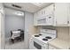 View of the kitchen looking towards the dining area, showing the microwave and oven at 614 Guild Dr # 10, Venice, FL 34285
