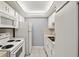 Galley kitchen featuring white appliances, cabinets, and tile flooring at 614 Guild Dr # 10, Venice, FL 34285