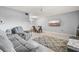 Comfortable living room area with tile flooring and a large grey sofa set next to the dining area at 614 Guild Dr # 10, Venice, FL 34285
