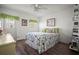 Cozy bedroom features hardwood floors, a ceiling fan, and colorful bedding at 614 N Waterway, Venice, FL 34285