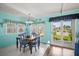 Bright dining room featuring a wood table, blue chairs, and cheerful turquoise walls with ample natural light at 614 N Waterway, Venice, FL 34285