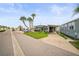 Charming home exterior featuring a covered carport and well-maintained landscaping with palm trees at 614 N Waterway, Venice, FL 34285