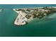 A scenic aerial shot of a peninsula and beach, with turquoise waters and the open sea on a bright day at 616 S Casey Key Rd, Nokomis, FL 34275