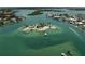 Aerial view of a island in the ocean, revealing crystal turquoise water, boats, beaches, and vegetation at 616 S Casey Key Rd, Nokomis, FL 34275