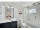 Bathroom featuring a white marble shower, dark vanity and a decorative mirror at 616 S Casey Key Rd, Nokomis, FL 34275