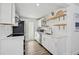 Modern white kitchen with stainless steel appliances and sleek design at 616 S Casey Key Rd, Nokomis, FL 34275