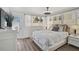 Bright main bedroom with a ceiling fan, white sheer curtains and wood floors at 616 S Casey Key Rd, Nokomis, FL 34275