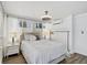 Bright main bedroom with a ceiling fan, white sheer curtains and wood floors at 616 S Casey Key Rd, Nokomis, FL 34275