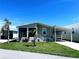 Inviting single-story home featuring a screened porch and covered parking, complemented by mature landscaping at 623 Leisure, Venice, FL 34285