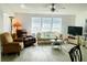 Comfortable living room featuring a ceiling fan, many windows, and a cozy seating area with neutral tones at 623 Leisure, Venice, FL 34285