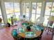 The well-lit screened porch offers scenic views and a relaxed atmosphere with a dining set at 623 Leisure, Venice, FL 34285