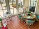 The bright and cozy screened porch features tile flooring and comfortable wicker furniture at 623 Leisure, Venice, FL 34285