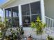Close-up view of the screened porch, showing the plants and the white brick base of the home at 623 Leisure, Venice, FL 34285