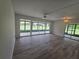 Bright living room featuring wood flooring, a ceiling fan, and large glass windows overlooking the backyard at 624 White Pine Tree Rd # 5, Venice, FL 34285