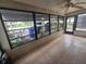 Bright sunroom with tile flooring and expansive windows overlooking the community gardens and nearby parking area at 624 White Pine Tree Rd # 5, Venice, FL 34285