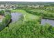 Scenic aerial of a lush golf course community with trees and lakes enhancing the picturesque surroundings at 6619 Pinefeather Ct, Bradenton, FL 34203