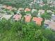 Wide aerial perspective of homes with red tiled roofs, manicured lawns, and wooded areas at 6619 Pinefeather Ct, Bradenton, FL 34203