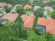 Overhead neighborhood shot with houses boasting tiled roofs, palm trees, and green lawns at 6619 Pinefeather Ct, Bradenton, FL 34203
