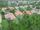 An aerial view of homes showcasing tile roofs, screened-in pools, and lush landscaping in a desirable community at 6619 Pinefeather Ct, Bradenton, FL 34203