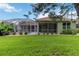 Well-manicured backyard with lush green grass and a view of the screened-in patio and pool at 6619 Pinefeather Ct, Bradenton, FL 34203
