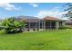 Lush backyard with a screened-in lanai and pool area surrounded by beautiful landscaping at 6619 Pinefeather Ct, Bradenton, FL 34203