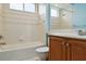 Well-lit bathroom with a bathtub, shower, and a double vanity with wood cabinets and ample counter space at 6619 Pinefeather Ct, Bradenton, FL 34203