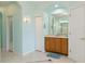 Bathroom showcasing a wood vanity with a large mirror, tile flooring, and a walk-in closet at 6619 Pinefeather Ct, Bradenton, FL 34203
