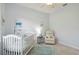 Bright bedroom features a white crib, a recliner and airplane-themed artwork at 6619 Pinefeather Ct, Bradenton, FL 34203