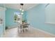 Bright dining room with a modern light fixture, table set for four, and large window providing natural light at 6619 Pinefeather Ct, Bradenton, FL 34203