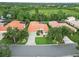 Aerial view showcasing homes with tile roofs, manicured lawns, and verdant surroundings at 6619 Pinefeather Ct, Bradenton, FL 34203