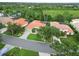 Bird's-eye view of homes with tile roofs, manicured lawns, and verdant surroundings at 6619 Pinefeather Ct, Bradenton, FL 34203