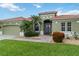 Charming exterior of a green home featuring a well-manicured lawn, desert landscaping, and a red tile roof at 6619 Pinefeather Ct, Bradenton, FL 34203
