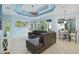 Living room with a comfortable leather sectional, ceiling fan, and sliding glass doors to the outside at 6619 Pinefeather Ct, Bradenton, FL 34203