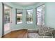 Sitting area featuring a comfortable chair with a view of the backyard pool through large windows at 6619 Pinefeather Ct, Bradenton, FL 34203