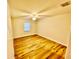 A cozy bedroom with hardwood floors, ceiling fan, and natural light from a window at 7201 Daiquiri Ln, Tampa, FL 33634