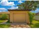 Attached one car garage with a brown door and house number under an extended roof at 7201 Daiquiri Ln, Tampa, FL 33634