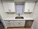 Stylish kitchen showcasing a stainless steel dishwasher and clean white cabinets with modern hardware at 7201 Daiquiri Ln, Tampa, FL 33634