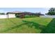 Expansive backyard featuring lush green grass and meticulously maintained landscaping, offering a private retreat at 7257 Maguire Ln, Englewood, FL 34224