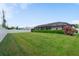 Spacious backyard featuring lush green grass, manicured landscaping, and a white fence, offering privacy and space at 7257 Maguire Ln, Englewood, FL 34224