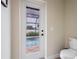 Bathroom with door leading to the pool and a white toilet at 7257 Maguire Ln, Englewood, FL 34224