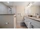 Modern bathroom featuring a walk-in shower, double vanity with granite countertops, and sleek fixtures at 7257 Maguire Ln, Englewood, FL 34224